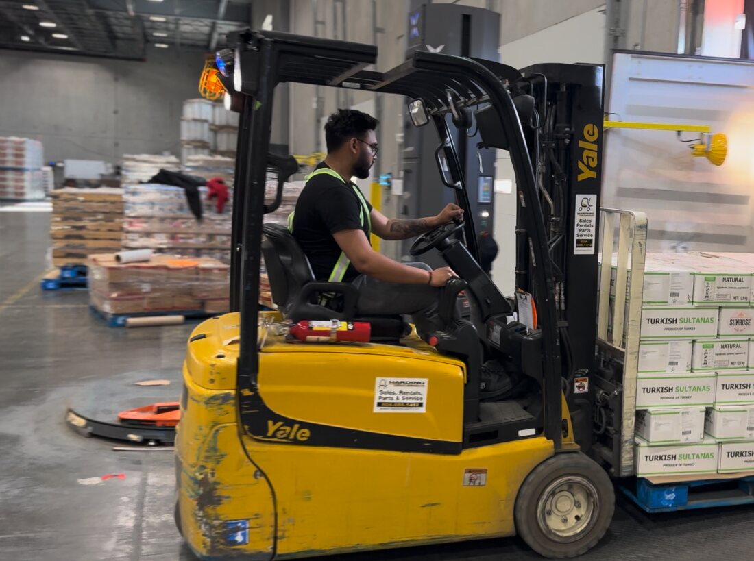 Express Lumpers forklift operator moving palletized freight in a Surrey warehouse