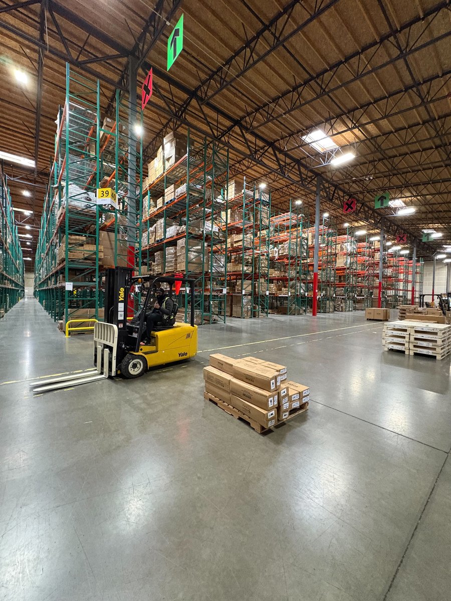 Express Lumpers certified forklift operator moving palletized freight through a Renton warehouse aisle