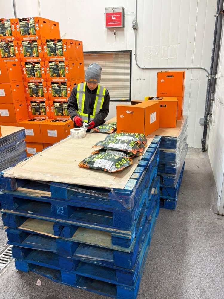 Express Lumpers associate relabeling and repackaging product bags on a pallet