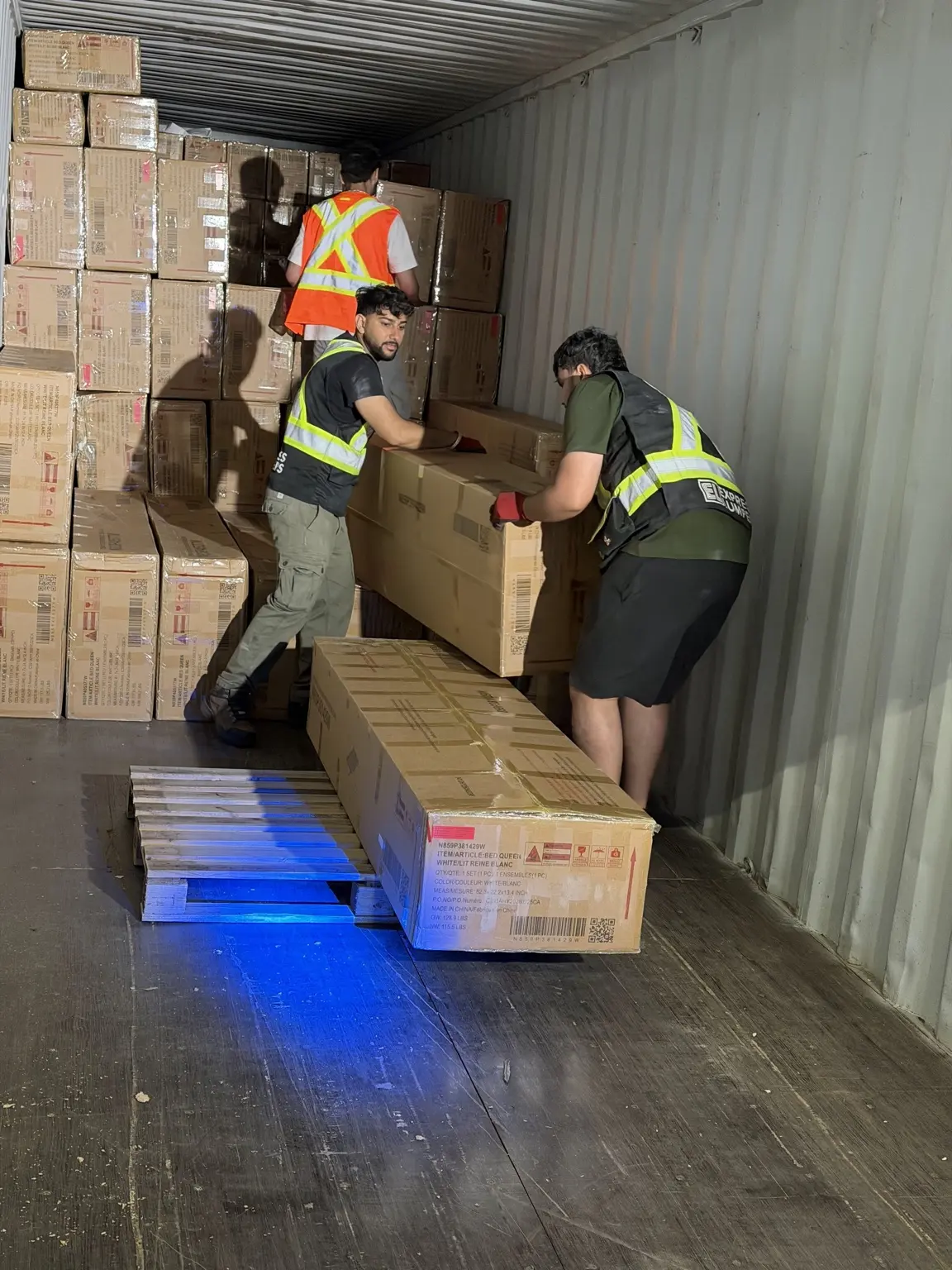 Express Lumpers associates handling freight inside a shipping container